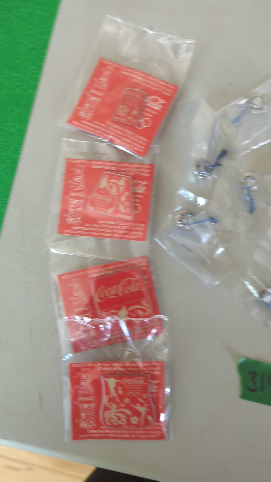 Coca-Cola metal keychains and paper coasters | Maxsold