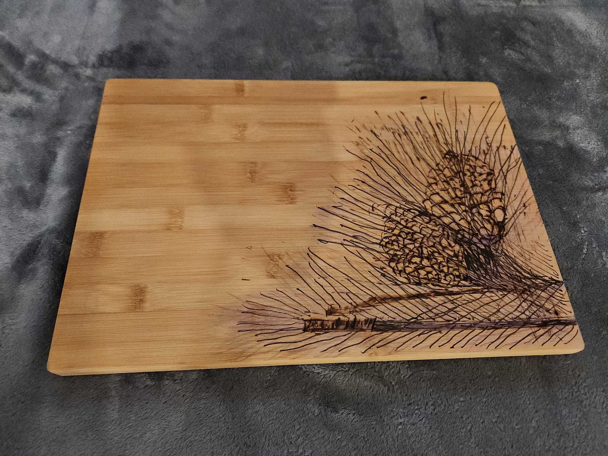 Rectangular bamboo cutting board with pinecone pyrography | Maxsold