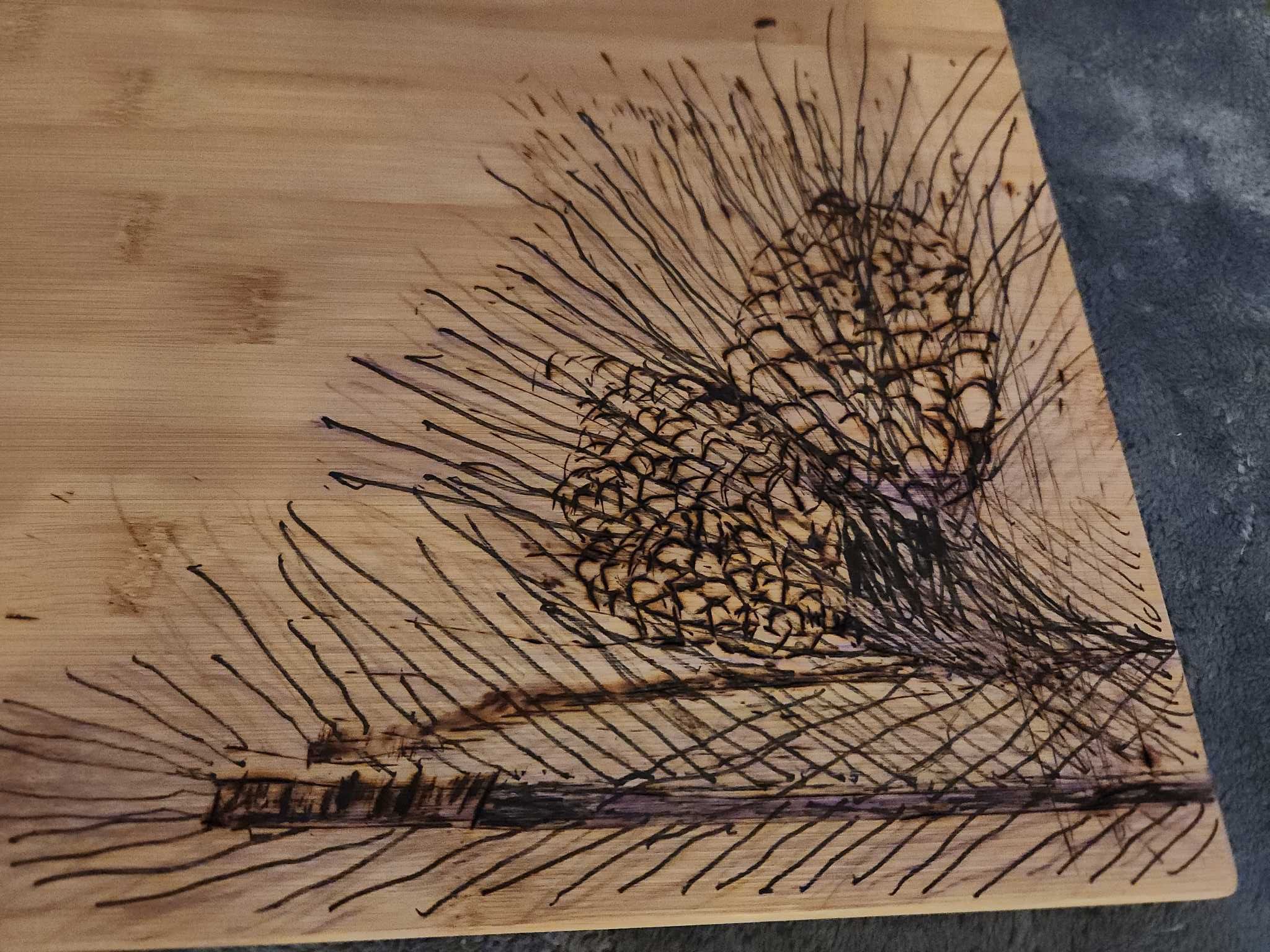 Rectangular bamboo cutting board with pinecone pyrography | Maxsold